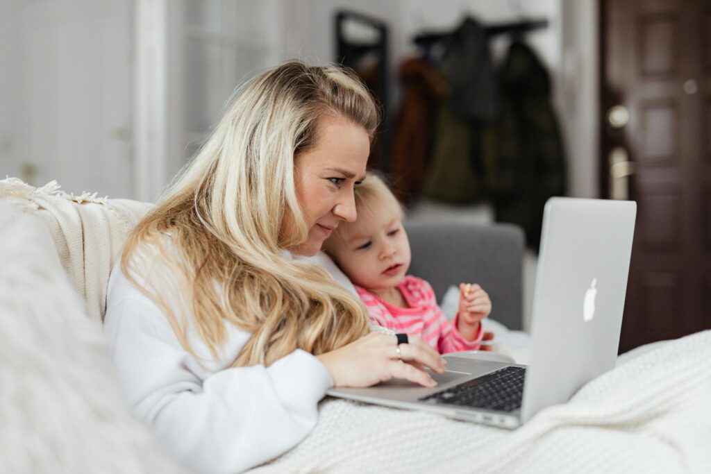 Woman in White Sweater Using her Macbook Pro